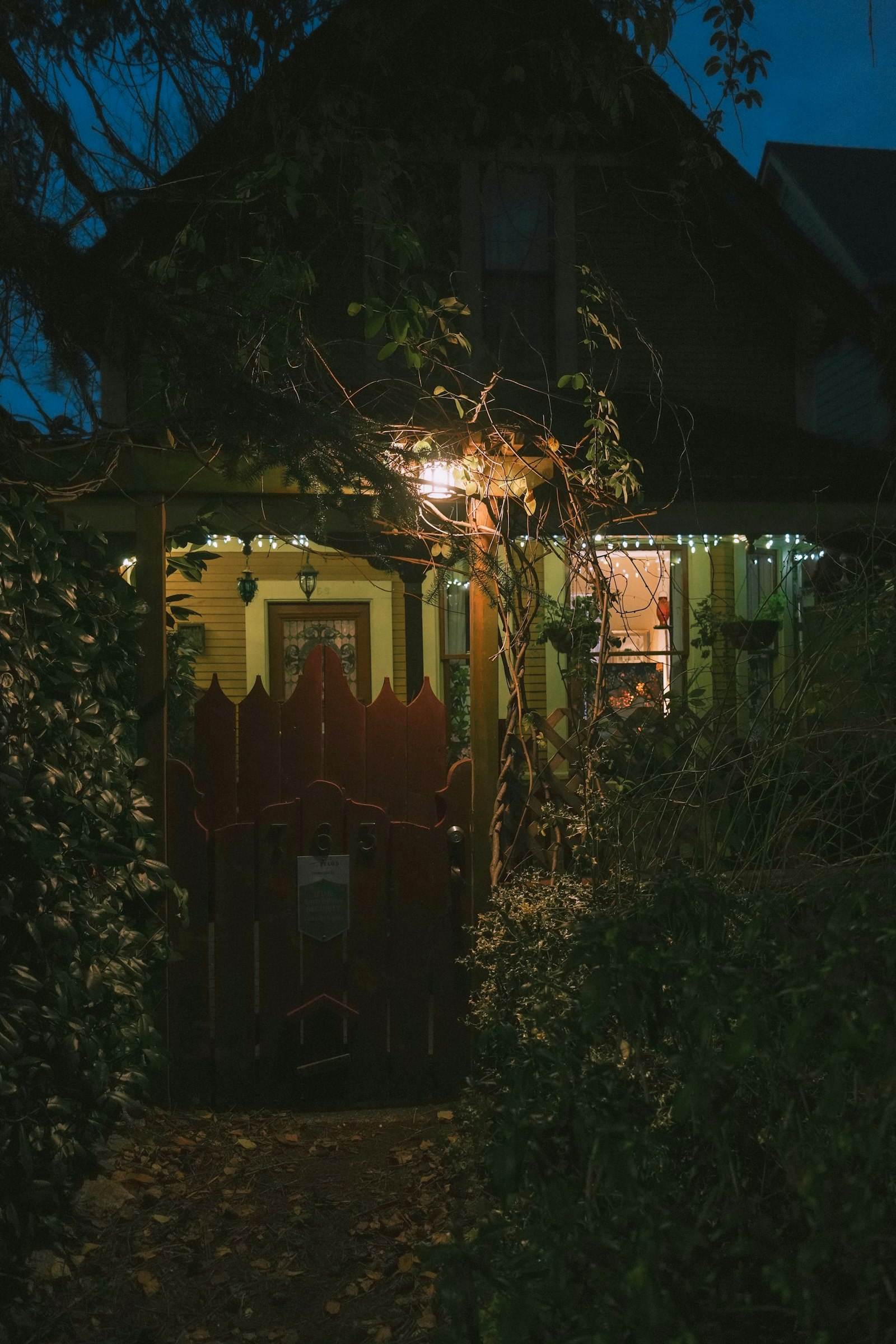 Front walk and garden gate at night leading toward a porch