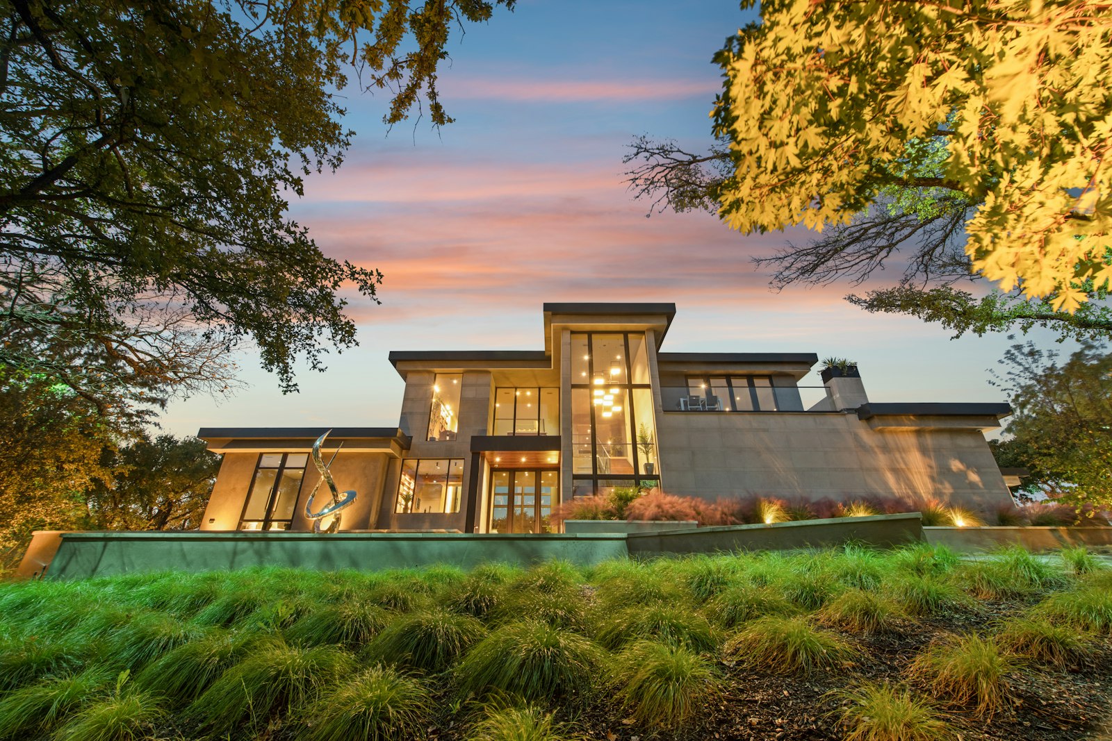 Residence at blue hour where architecture, planting, and outdoor fixtures are visible together