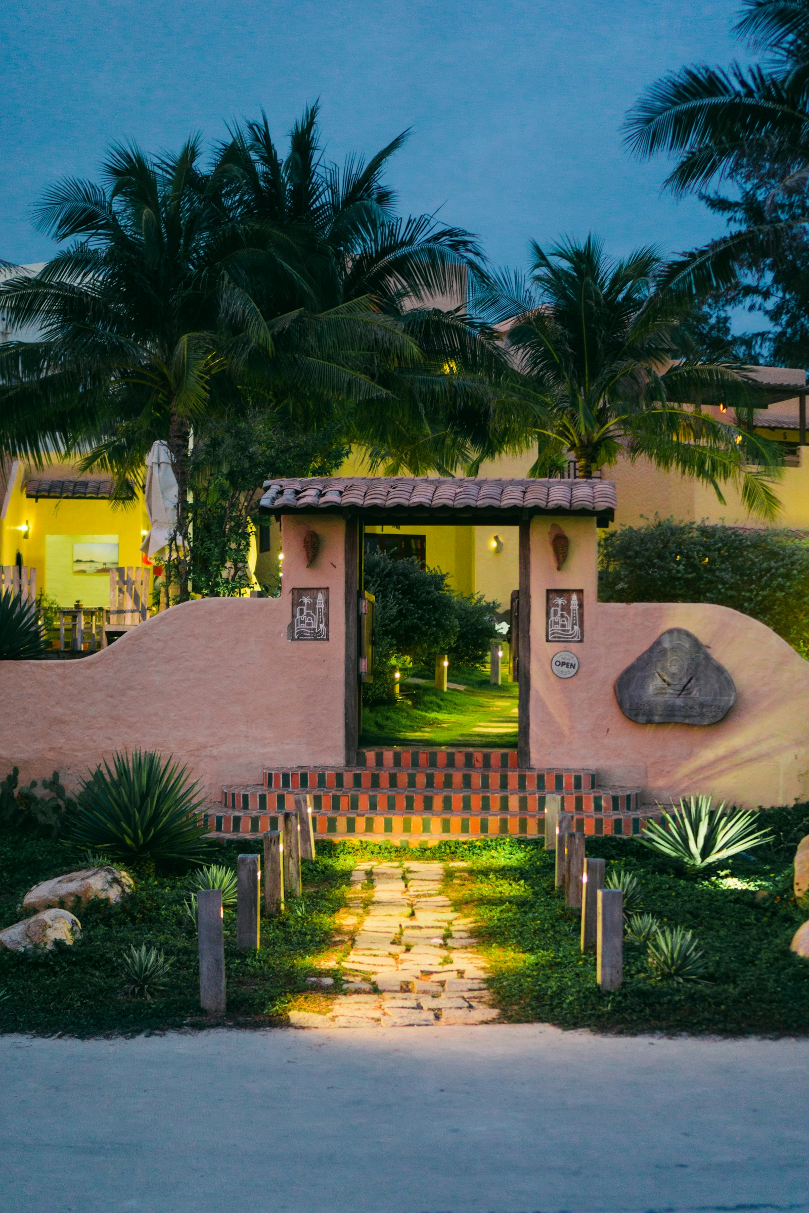 Garden walk and brick steps at dusk with low lights on the walking surface