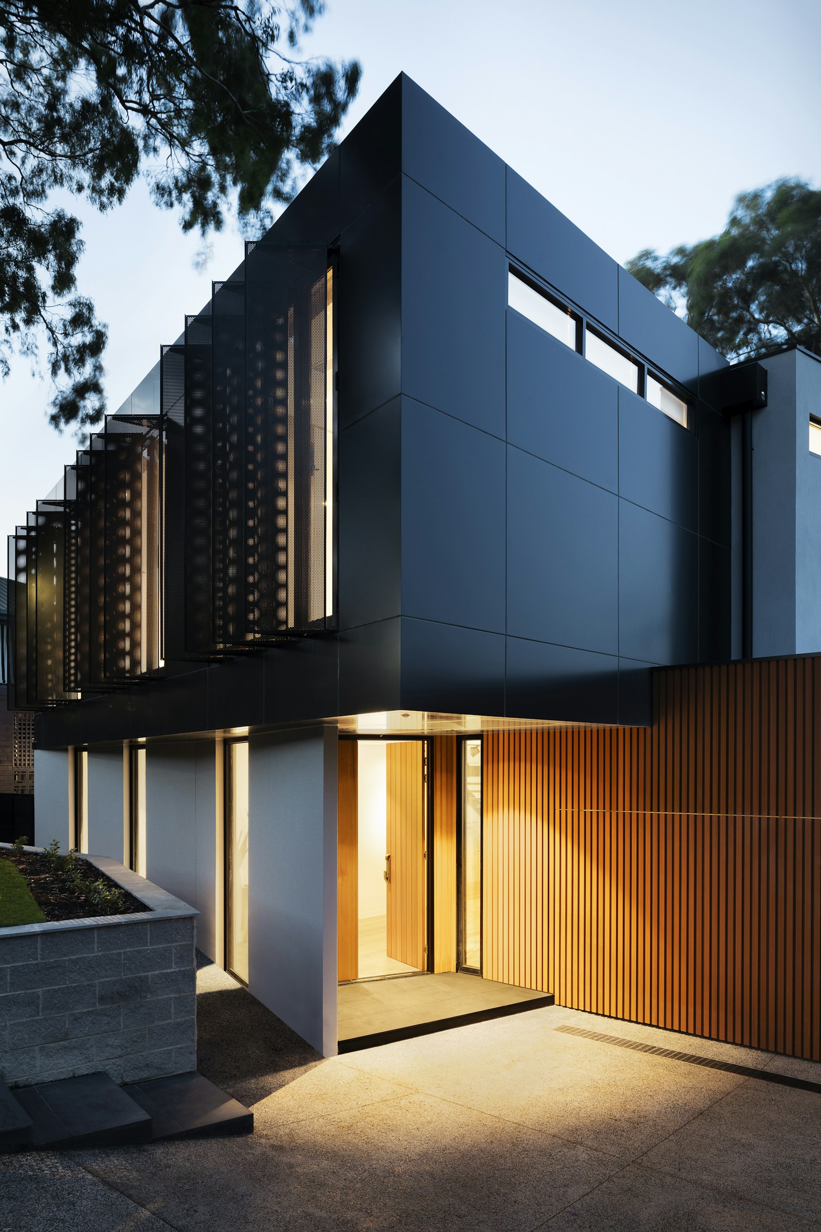 Covered front entry at dusk with a warm downlight over the door